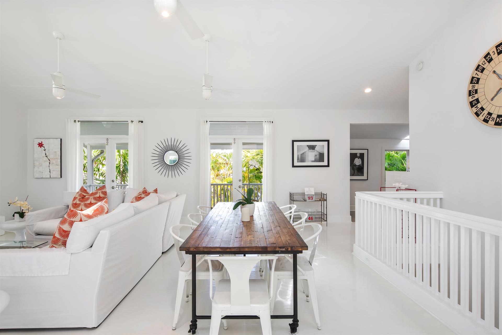 Open-plan living and dining with reclaimed wood table, white furnishings, and vaulted ceilings
